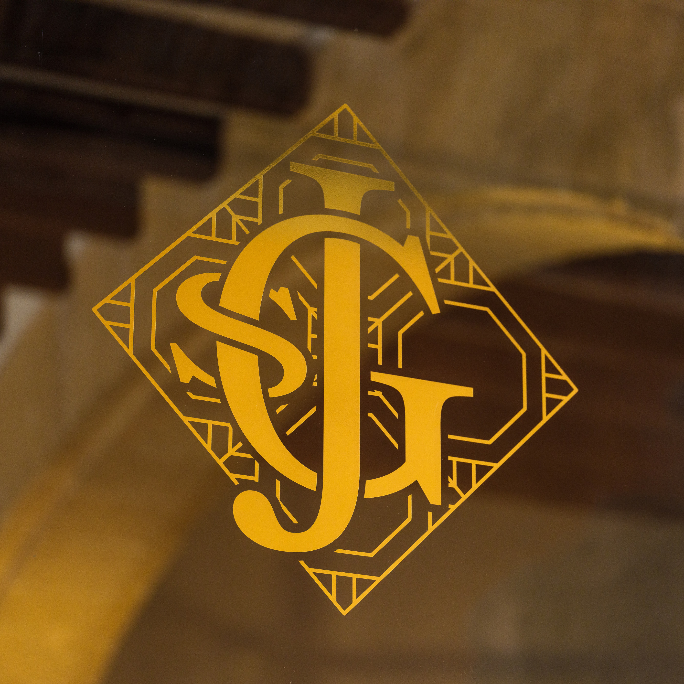 The Glòria monogram in brass