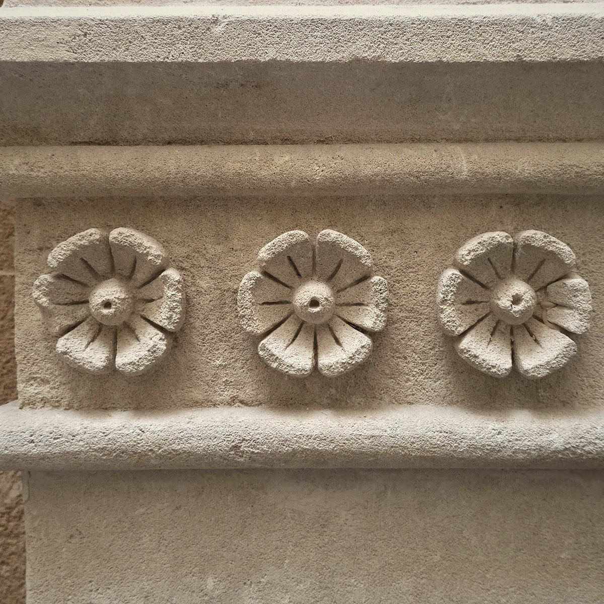 A row of carved stone rosettes in the historic house of Glòria