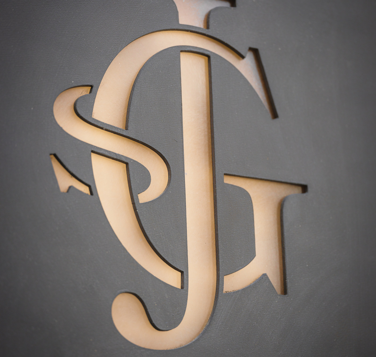 The Glòria monogram in brass on stone