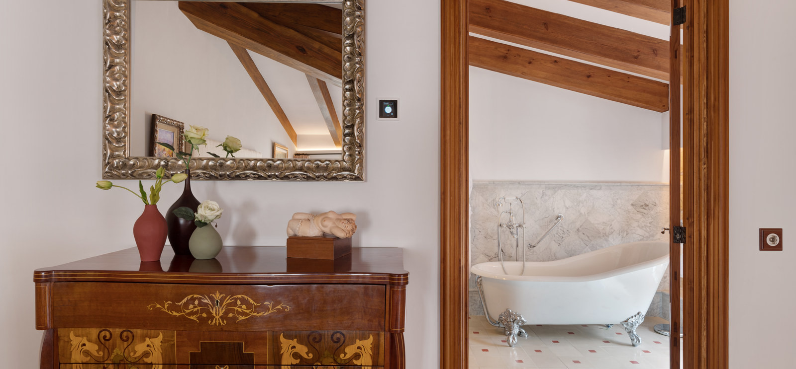 A room with an antique mirror and a freestanding bath at Glòria